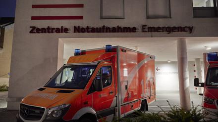 Ein Schriftzug der Zentralen Notaufnahme ist an einem Gebäude der Charité · Universitätsmedizin zu sehen, während davor ein Rettungswagen steht. 