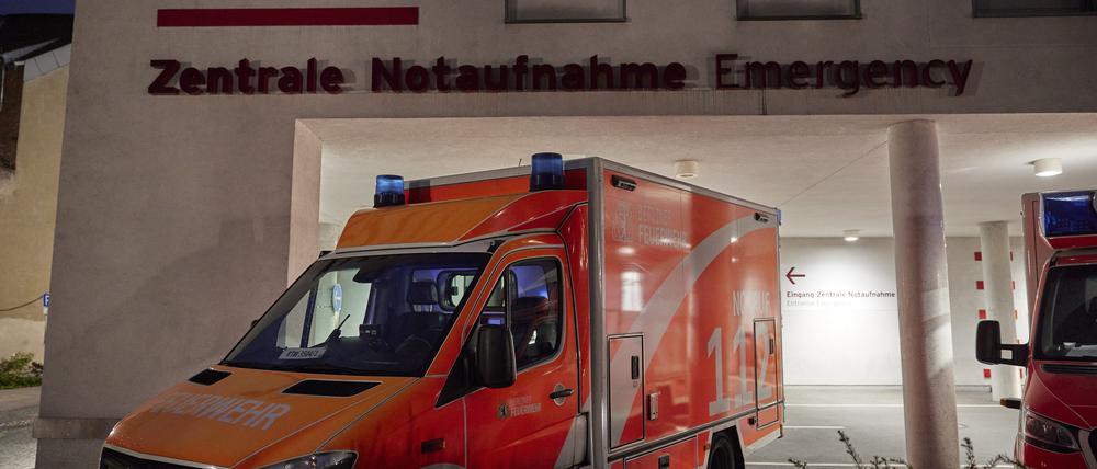 Ein Schriftzug der Zentralen Notaufnahme ist an einem Gebäude der Charité · Universitätsmedizin zu sehen, während davor ein Rettungswagen steht.