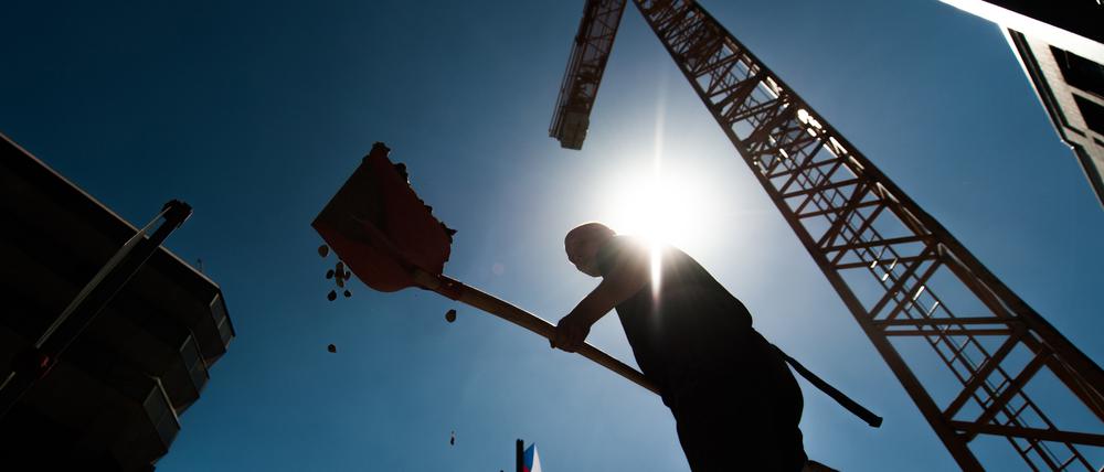 Ein Bauarbeiter arbeitet mit einer Schaufel (Symbolbild).