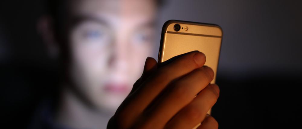 Ein Jugendlicher schaut auf sein Smatphone. (Symbolbild)