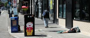 Ein Mann liegt auf dem Fußweg in Downtown Portland. In den USA ziehen Opioide Menschen seit Jahren in den Abgrund. Den Schmerzmitteln wird oft „Tranq“ oft beigemischt.