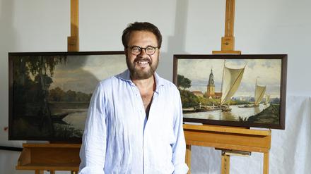 Restaurator Oliver Max Wenske vor zwei Potsdam-Landschaften von Max Koch für die Ausstellung im Museum der Havelländischen Malerkolonie in Ferch.