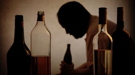 
Ein Mann sitzt vor mehreren alkoholischen Getränken.