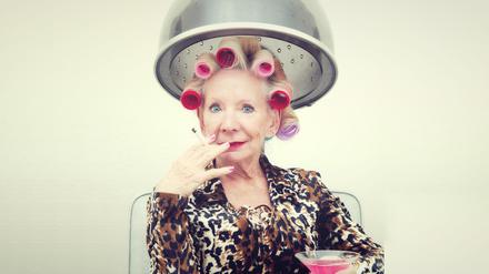 Sie hat die Haare schön. Eine Dame beim Lockenwickeln.