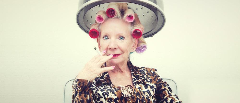 Sie hat die Haare schön. Eine Dame beim Lockenwickeln.