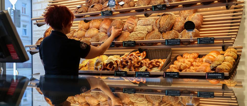 Eine Mitarbeiterin räumt Mischbrot in die Auslage einer Bäckerei (Symbolbild).