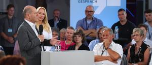 Bundeskanzler Olaf Scholz (l, SPD) steht bei einem Kanzlergespräch mit Bürgerinnen und Bürgern im Festspielhaus.