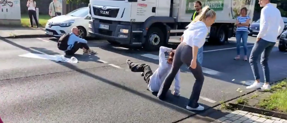 Auf einem Video, das von der Aktion in Bottrop auf Twitter gepostet wurde, ist zu sehen, wie eine Demonstrantin von einer Frau an den Haaren gezogen und von der Fahrbahn geschleift wird.