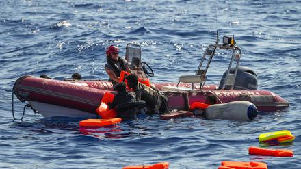 Ein Mitglied der spanischen Nichtregierungsorganisation Open Arms hilft Migranten, an Bord zu kommen, nachdem ihr Holzboot während einer Rettungsaktion südlich der italienischen Insel Lampedusa im Mittelmeer gekentert war. 