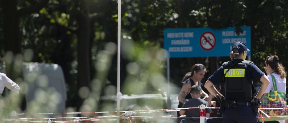 Eine Polizeibeamtin beobachtet am Prinzenbad in Kreuzberg die ankommenden Badegäste.
