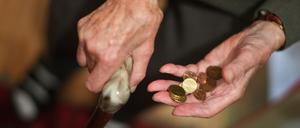 Eine Rentnerin hält ein paar Münzen in der Hand. (Symbolbild)