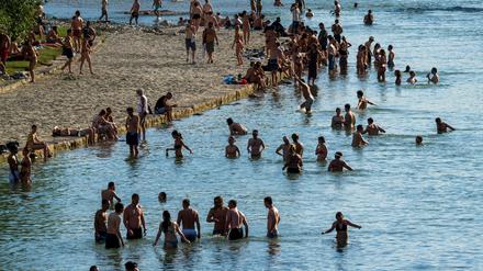 Menschen suchen in der Isar in München Abkühlung vor den heißen Temperaturen. 