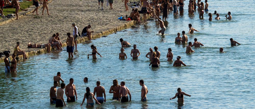 Menschen suchen in der Isar in München Abkühlung vor den heißen Temperaturen.