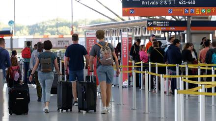Reisende gehen im Flughafen Köln/Bonn durch die Abflughalle: Flüge ins Ausland sind deutlich teurer geworden. Auch Pauschalreisen kosten etwa 10 Prozent mehr im Vergleich zum letzten Jahr. 