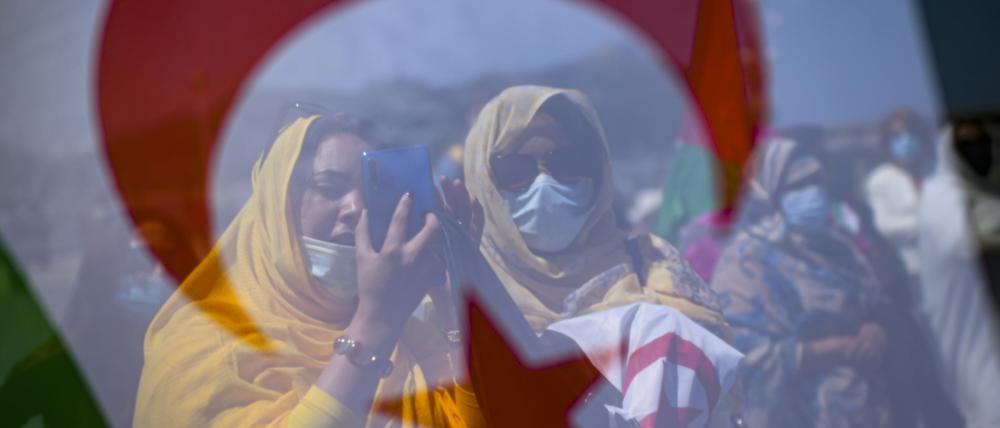 Saharische Demonstrantinnen stehen hinter einer Fahne der Westsahara bei einem Protest zur Unterstützung des Chefs der Unabhängigkeitsbewegung Polisario in Westsahara am Strand von La Concha. 