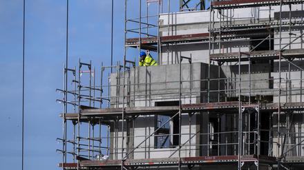 Ein Bauarbeiter steht auf einem Balkon auf einer Baustelle von einem neu gebauten Wohnhaus im Berliner Südosten. (Symbolbild)