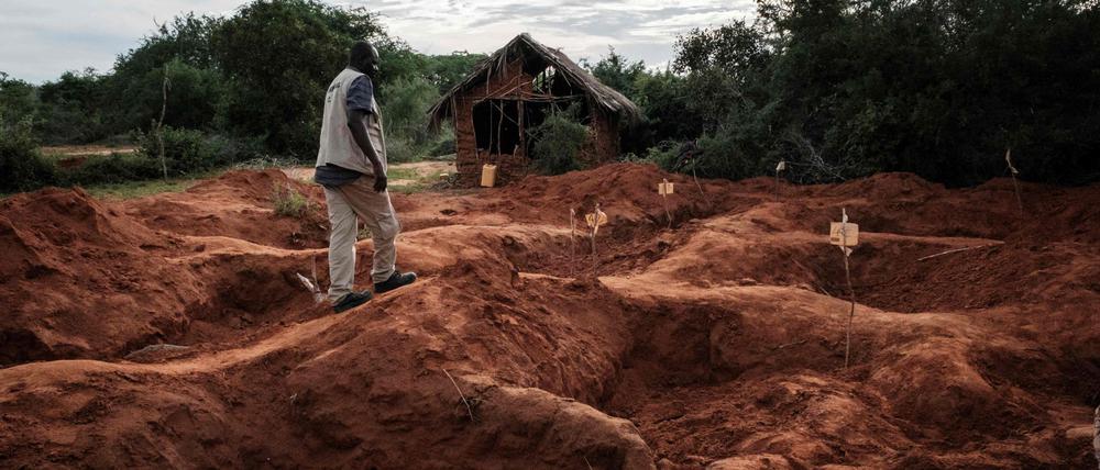 Ein Kriminalbeamter geht das Massengrab in Shakahola nahe der Küstenstadt Malindi in Kenia ab: Über 400 Opfer haben die Behörden bis jetzt festgestellt.