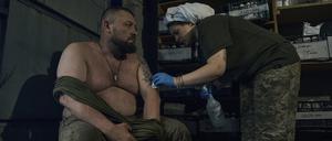 Eine Sanitäterin des Militärs behandelt einen verletzten ukrainischen Soldaten in einem Feldlazarett. 