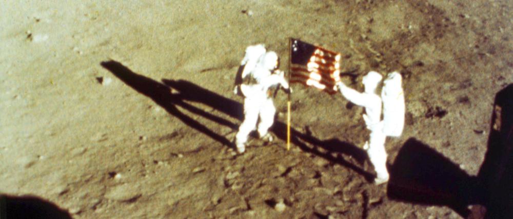 Neil Armstrong und Buzz Aldrin an der US-amerikanischen Flagge.