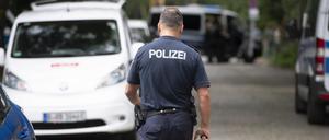 20.07.2023, Brandenburg, Kleinmachnow: Ein Polizist läuft bei einer Suchaktion nach einem freilaufenden gefährlichen Wildtier im Bereich der südlichen Landesgrenze von Berlin eine Straße entlang. Ein gefährliches Wildtier ist in der Nacht zum Donnerstag in Brandenburg entlaufen und hat eine große Suchaktion ausgelöst. Wie die Polizei auf Anfrage der Deutschen Presse-Agentur mitteilte, suchten Einsatzkräfte mit Hubschraubern in Kleinmachnow und angrenzenden Gemeinden nach dem Tier. Foto: Paul Zinken/dpa +++ dpa-Bildfunk +++