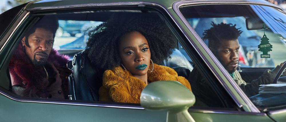 Der Style von Yo-Yo (Teyonah Parris), Slick Charles (Jamie Foxx) und Fontaine (John Boyega) stammt aus den 1970ern, aber die Bedrohung ist gegenwärtig.