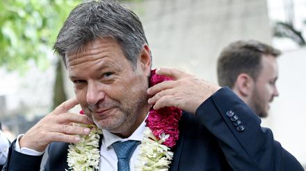 Robert Habeck (Bündnis 90/Die Grünen), Vizekanzler und Bundesminister für Wirtschaft und Klimaschutz, wird mit einer Blumenkette bei einem Unternehmensbesuch des deutschen Brennstoffzellhersteller SFC Energy begrüßt.