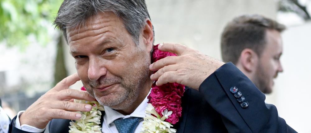 Robert Habeck (Bündnis 90/Die Grünen), Vizekanzler und Bundesminister für Wirtschaft und Klimaschutz, wird mit einer Blumenkette bei einem Unternehmensbesuch des deutschen Brennstoffzellhersteller SFC Energy begrüßt.