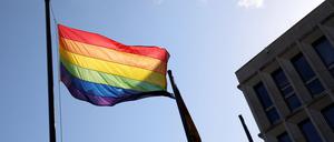 Eine Regenbogenflagge weht vor einem Gebäude.