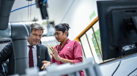 Robert Habeck (Bündnis 90/Die Grünen) unterhält sich mit einer Auszubildenden bei einem Unternehmensbesuch bei Siemens Kalwa.