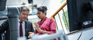Robert Habeck (Bündnis 90/Die Grünen) unterhält sich mit einer Auszubildenden bei einem Unternehmensbesuch bei Siemens Kalwa.