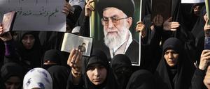 Demonstranten halten Kopien des Korans und Porträts des iranischen Obersten Führers Khamenei während eines Protests vor der schwedischen Botschaft.