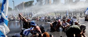 Die Polizei setzt Wasserwerfer gegen Demonstrierende ein.