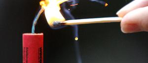 Ein handelsüblicher "China Knaller" wird am Mittwoch (27.12.2006) in Hannover mit einem Streichholz entzündet. Die Polizei warnt dringend davor, zu Silvester illegal nach Deutschland geschmuggelte Knaller und Raketen zu zünden. Die meisten illegalen Böller kämen aus Osteuropa oder Asien, wo sie billig nachgebaut werden. Nach Schätzungen der Polizei liegt die Gesamtmenge «im Tonnenbereich». Foto: Jochen Lübke dpa/lni +++(c) dpa - Bildfunk+++