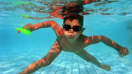 Der sechsjaehrige Rouven taucht am Dienstag (24.06.03) mit seiner Wasserpistole und Chlorbrille im Schwimmbad des suedhessischen Pfungstadt ab und entkommt so der Hitze.Foto: Thomas Lohnes/ddp