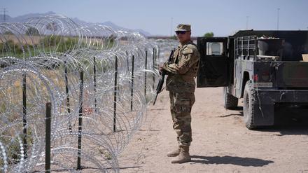 Ein US-Soldat steht an der Grenze zwischen den USA und Mexiko.
