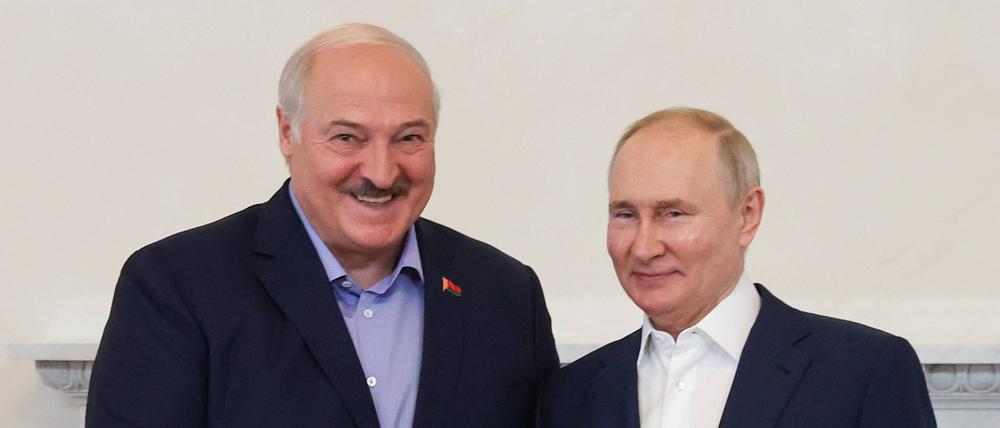 Der belarussische Machthaber Alexander Lukaschenko schüttelt seinem russischen Amtskollegen Wladimir Putin während eines Treffens in St. Petersburg die Hand.