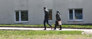 Asylbewerber gehen auf dem Gelände der Erstaufnahmeeinrichtung des Landes Thüringen spazieren.