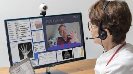 Eine Ärztin kommuniziert mit dem Patienten über eine Webcam.