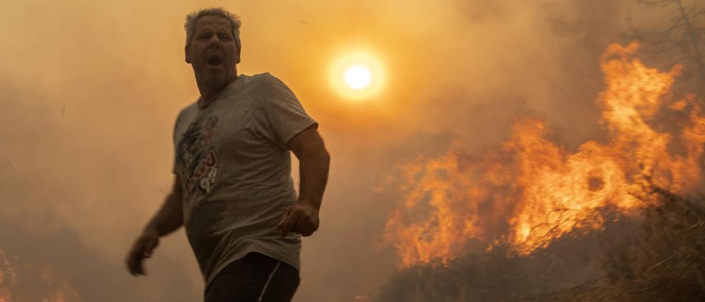 Ein Einheimischer flieht vor den Flammen von einem Waldbrand im Dorf Gennadi auf Rhodos.