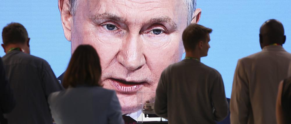 Teilnehmer schauen auf einen Bildschirm, der die Ansprache von Russlands Präsident Putin bei der Plenarsitzung des Russisch-Afrikanischen Wirtschafts- und Humanitären Forums überträgt.