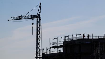 Bauarbeiter stehen auf der Baustelle eines Mehrfamilienhauses. Die Bundesregierung verfehlt ihre Ziele im Wohnungsbau. Gleichzeitig leben Menschen in Deutschland auf immer mehr Wohnfläche.
