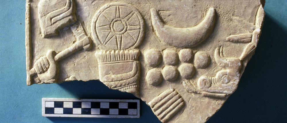 Stück der FU-Sammlung: ein reliefiertes Steinplattenfragment aus Tell Schech Hamad. Es zeigt den Wettergott Hadad (mit Hand und Kopfschmuck).