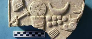 Stück der FU-Sammlung: ein reliefiertes Steinplattenfragment aus Tell Schech Hamad. Es zeigt den Wettergott Hadad (mit Hand und Kopfschmuck).