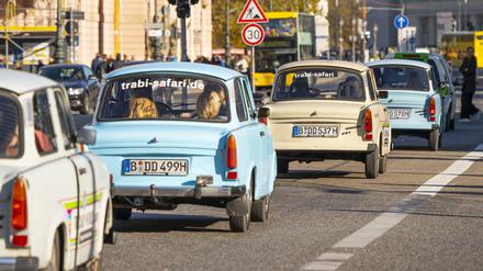 Touristen erkunden per Trabant die Innenstadt von Berlin, hier auf der Straße Unter den Linden.