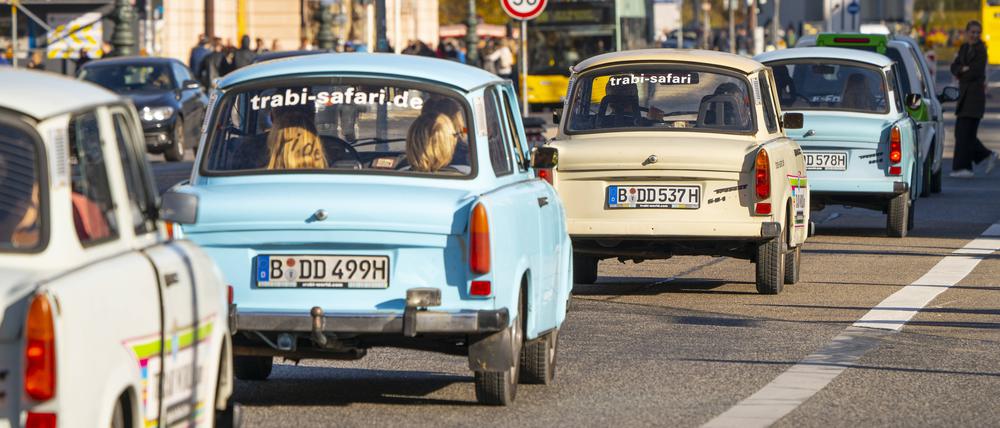 Touristen erkunden per Trabant die Innenstadt von Berlin, hier auf der Straße Unter den Linden.