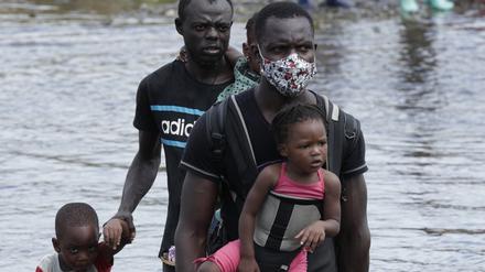 Migranten aus Haiti überqueren den Fluss Tuquesa nach einer Reise zu Fuß durch den Dschungel in der Provinz Darién.