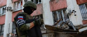 Ein russischer Kämpfer ist in der Ukraine vor einem zerstörten Haus zu sehen.