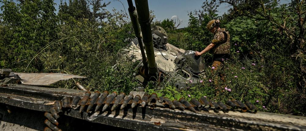 Ein ukrainischer Soldat inspiziert einen zerstörten russischen BMP-3-Panzer in der Region Saporischschja, am 21. Juli 2023. Wenige Tage später haben ukrainische Truppen offenbar einen BMP-1-Panzer unbemannt über ein Minenfeld geschickt.