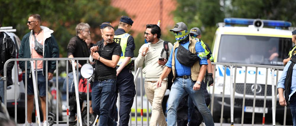 Salwan Momika, der eine Koranausgabe und die irakische Flagge verbrennen wollte, wird am 20. Juli in Stockholm von Polizisten abgeführt.