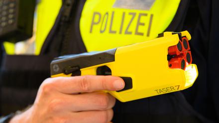 Ein Polizeibeamter hält im Rahmen der Pressekonferenz des Polizeipräsidenten im Jahr 2021 einen Taser in der Hand.